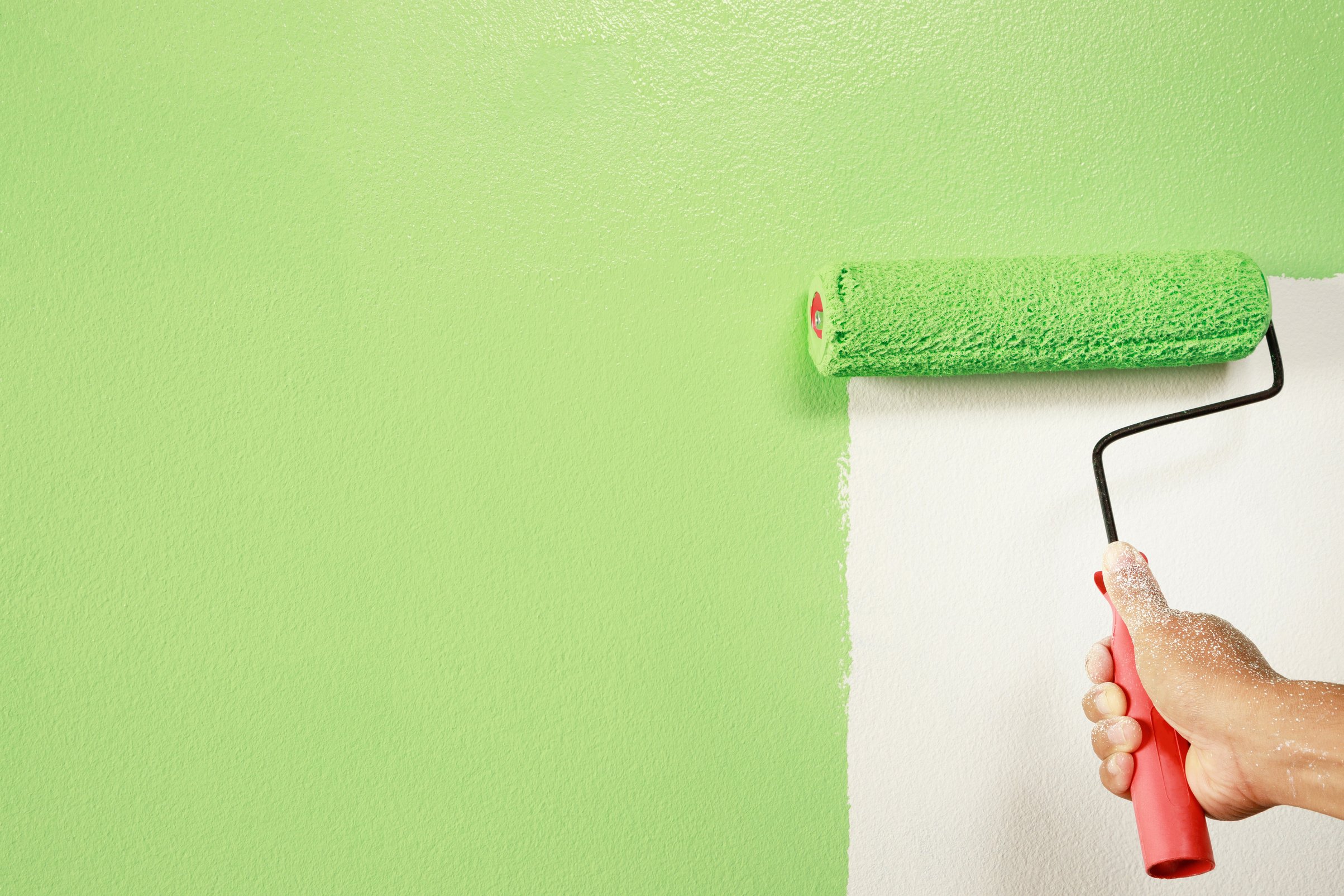 Person Painting Wall with Green Paint